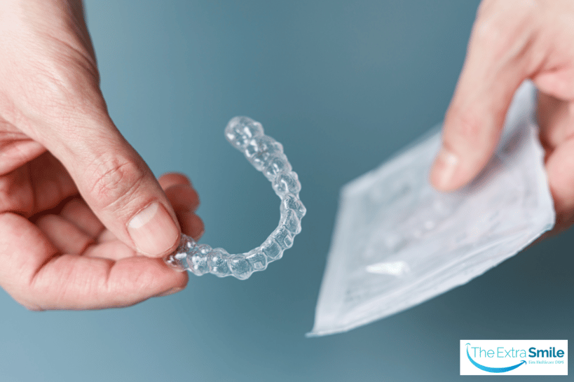 Closeup of new Invisalign aligner held in hand.